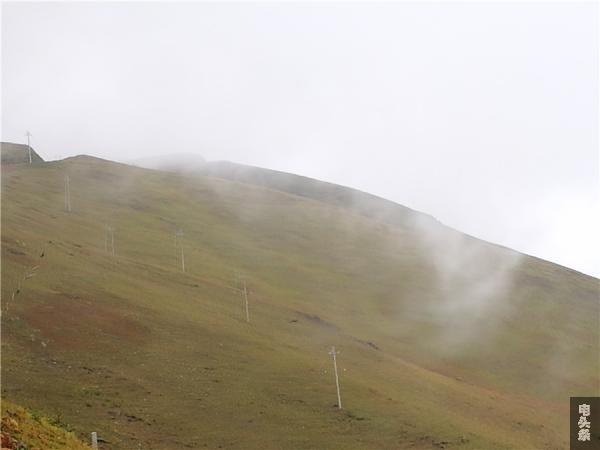 草山上在弥雾之中的供电线路。  王吉聪  摄