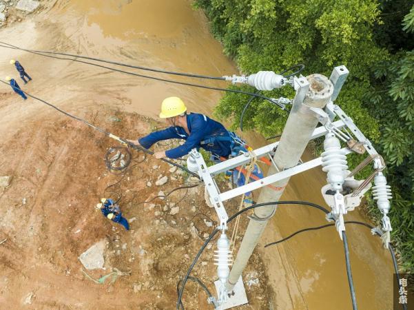 7、2023年8月23日，在广西梧州市高旺路提升改造工程施工现场，电力施工人员正在架设10千伏高旺输电线路。（何华文）