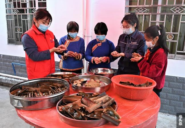 图11：1月11日，在龙门蓝田瑶乡小洞村，南方电网广东惠州供电局志愿者和村民一道，制作当地瑶族特色美食糍粑。 温秀云 摄