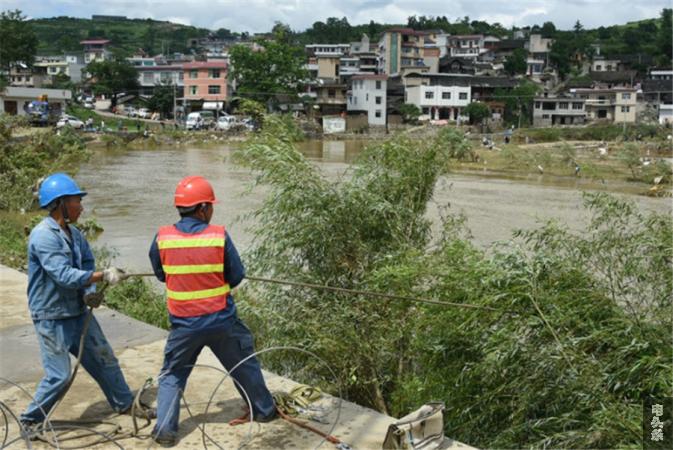 6月24日，福泉局正在抢修因洪灾冲毁的电力设备（文贤春）