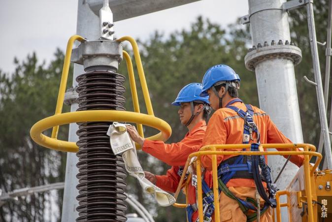 13、2021年12月22日，在广西梧州市苍梧县220千伏奇容变电站内，工作人员正在进行投运送电前的擦洗、检查工作。（何华文）