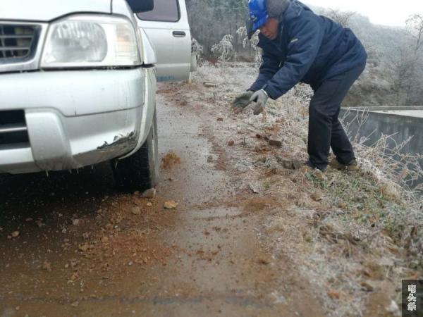 车辆在结冰的路面上无法通行，杨光辉用手挖起路边的泥土“铺路”张黎明摄2