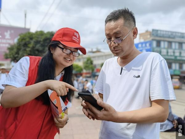 7月15日，南方电网云南曲靖师宗供电局在县城最热闹的地段“摆摊”支点，向过往群众介绍安全用电常识、网上缴费步骤，并手把手的教会大家如何领取8