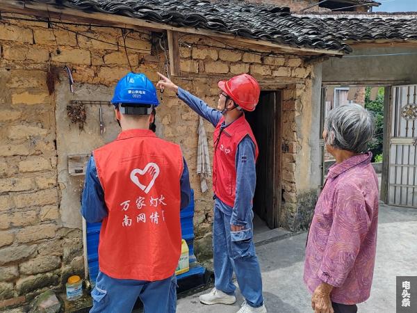 南方电网广西新电力集团蒙山供电局团员帮助吴金坪家进行线路隐患排查（拍摄：覃桂媛）
