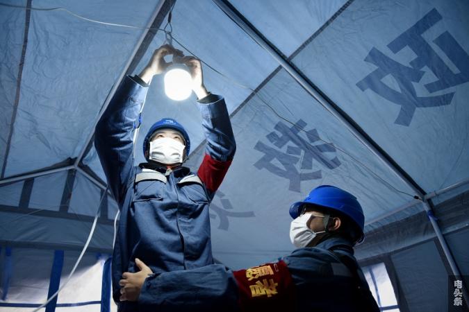 供电人员为关岭县花江镇疫情防控检测点接通电源。（易黎 摄）