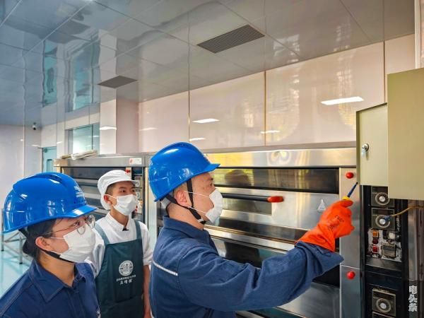 3、帮助月饼厂检查用电设备。（杜明彦 刘树悯 摄）