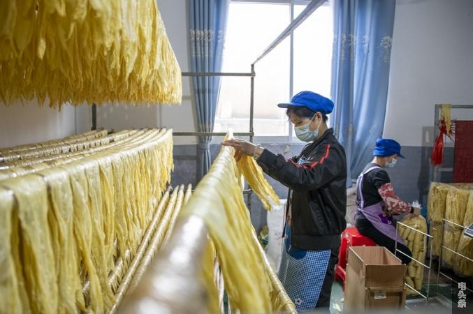 4、2022年3月1日，在广西梧州市苍梧县京南镇梧州市恒润食品腐竹厂生产车间内，工人忙着包装腐竹。（何华文）