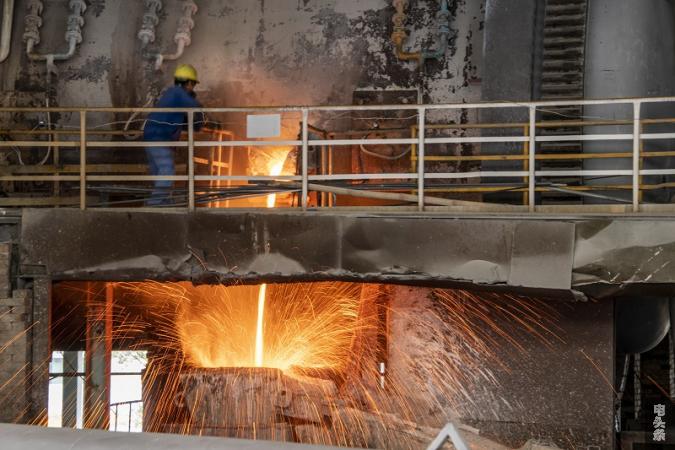 2022年1月19日，在广西梧州市金升铜业股份有限公司冶炼车间，工人们正在浇包放铜液。(何华文）