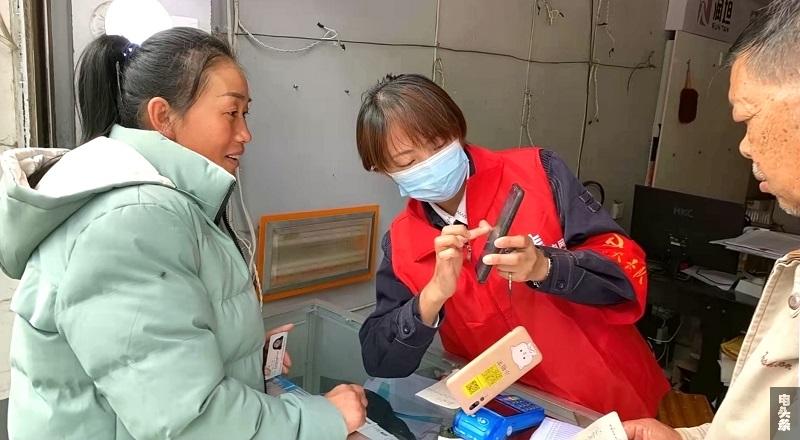胡静（中)上门指导客户绑定南方电网95598公众号，方便查询、缴纳电费