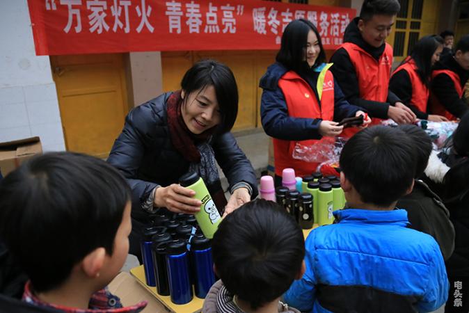 图为驻村书记吴长碧为孩子们发放暖冬物品（需道平摄）22-bj