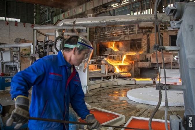 2022年1月19日，在广西梧州市金升铜业股份有限公司冶炼车间内，工人们正在浇包放铜液。(何华文）