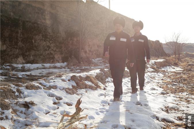 4-项目经理吴锡敏和项目部技术负责人陈锐锋踏着雪地在施工现场周围勘察地形——杨惠平  摄