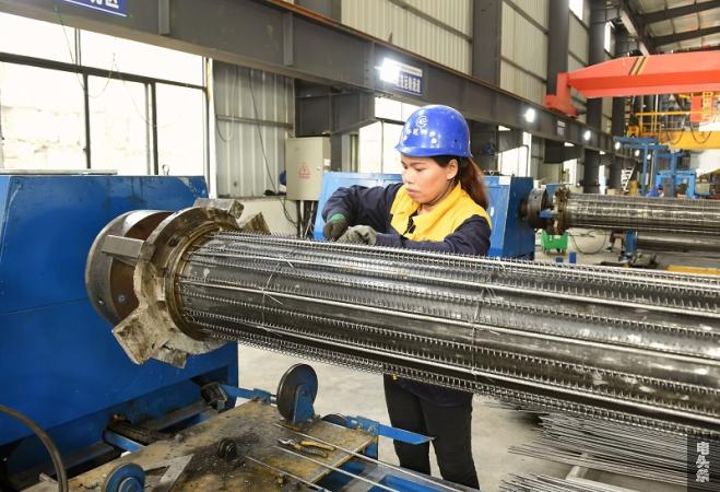 贵州电网公司扶贫产业“新型电杆厂”工人正在进行电杆生产制笼作业（王进 摄）