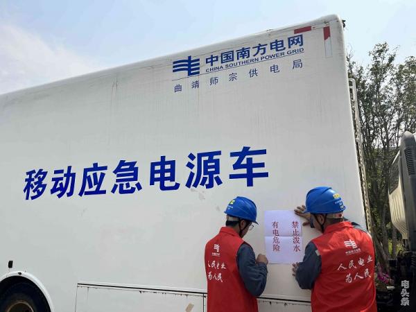 工作人员在发电车上粘贴提示。杨淑娟摄