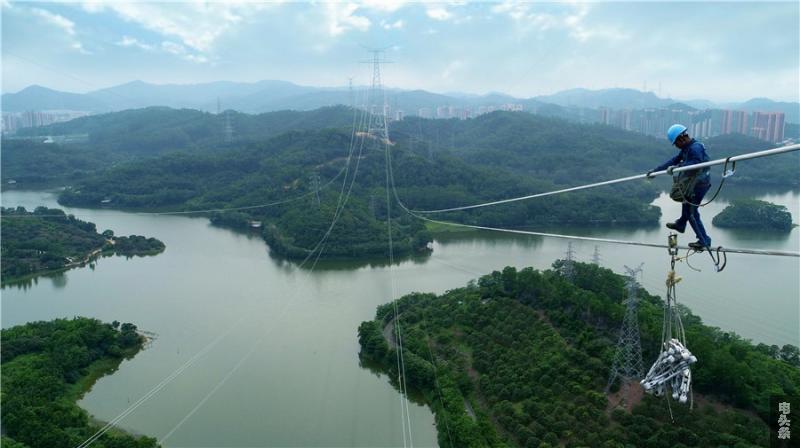 纵江二期电网建设工程，高空作业人员正在调整巨型放线滑车。陈海东 摄